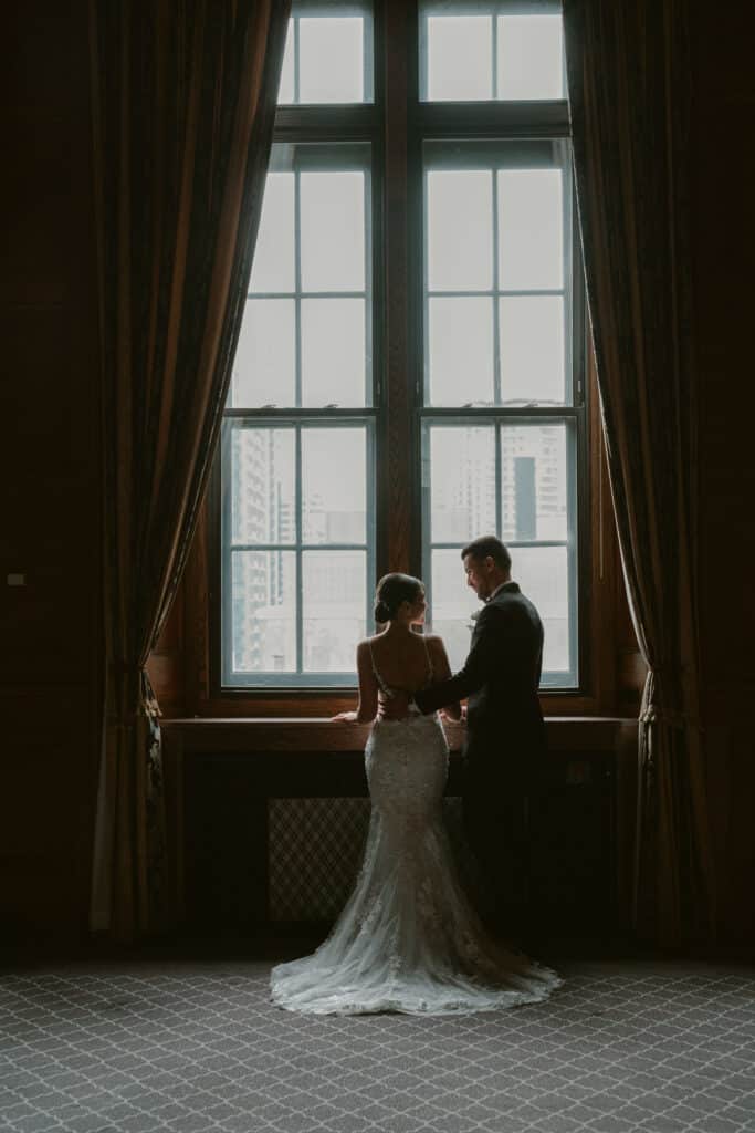 Bride and Groom looking out of a window