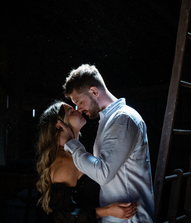 A man and woman kissing in the dark.