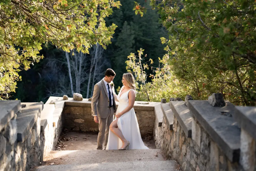 A man and woman standing on the side of a bridge.