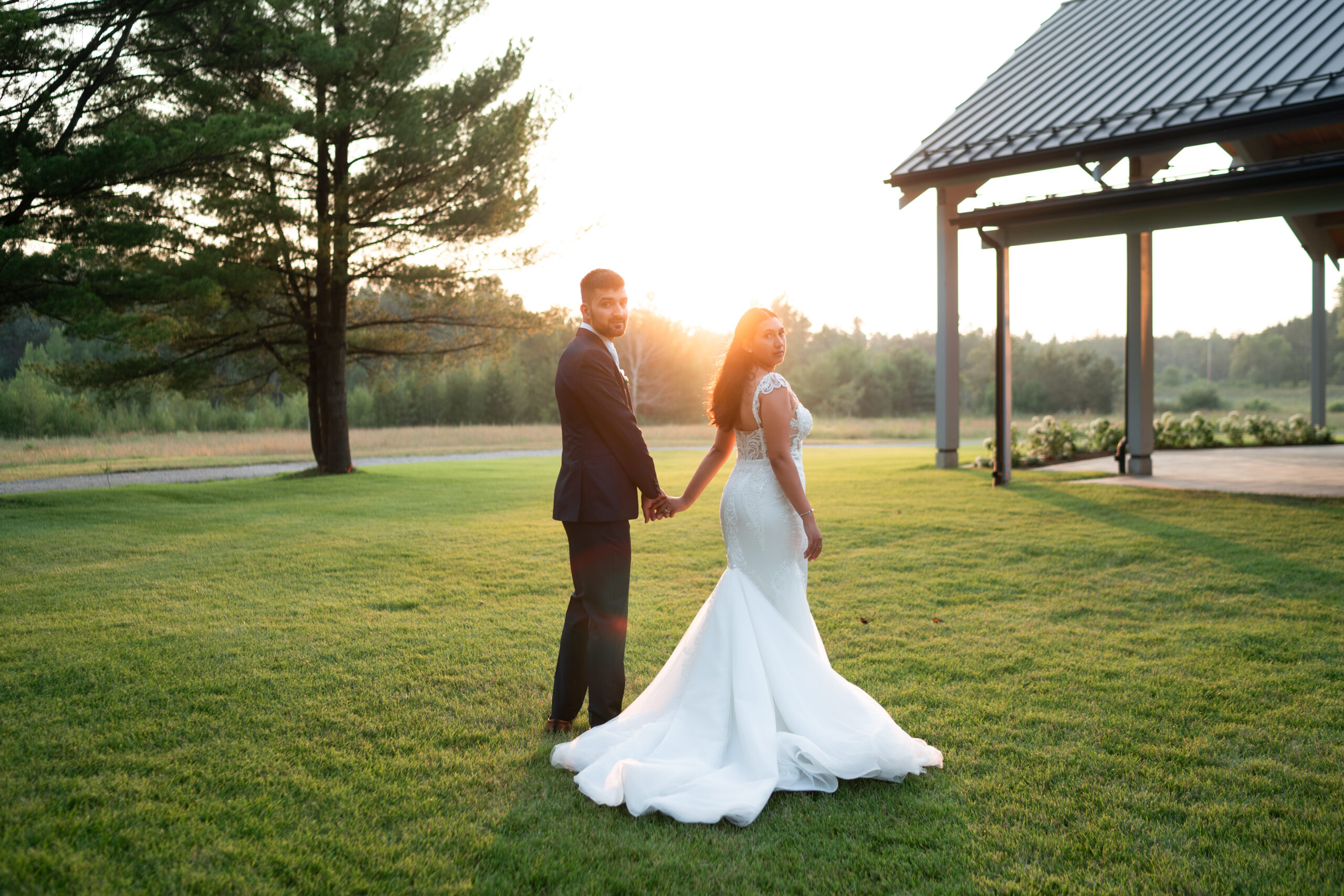 bride and groom holding hands in the sunset