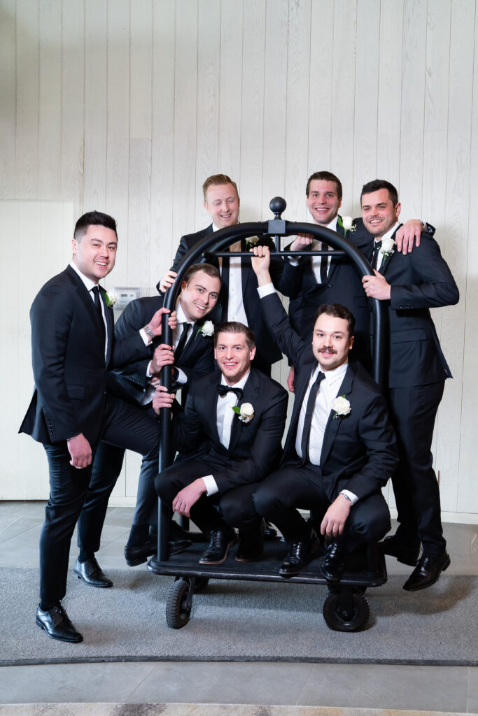 groomsmen on pull cart in hallway at pearle hotel