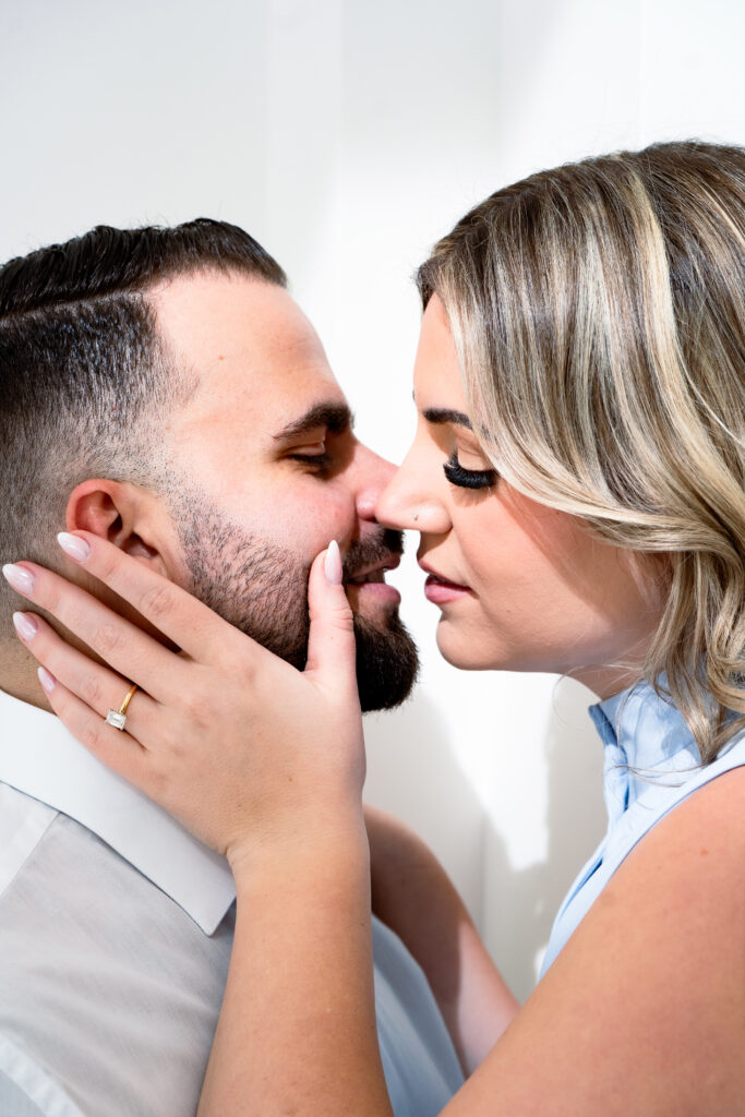 bride holding groom face and about to kiss him