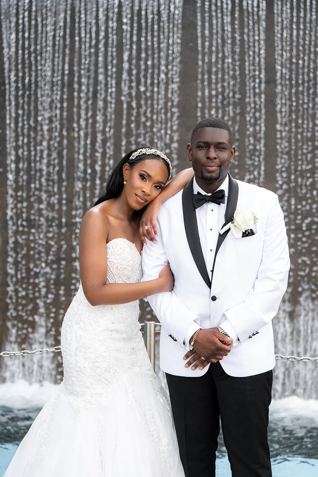 bride and groom in front of the waterfall at Spencers Restaurant in Burlington